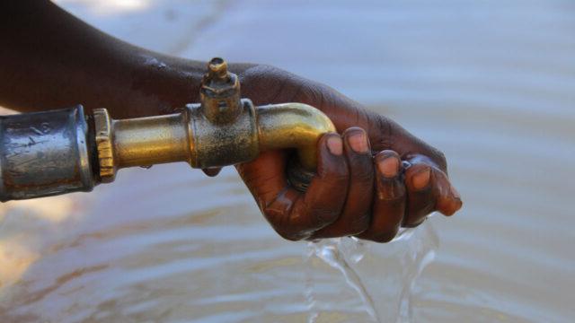 Hand cupped beneath faucet with clean water flowing